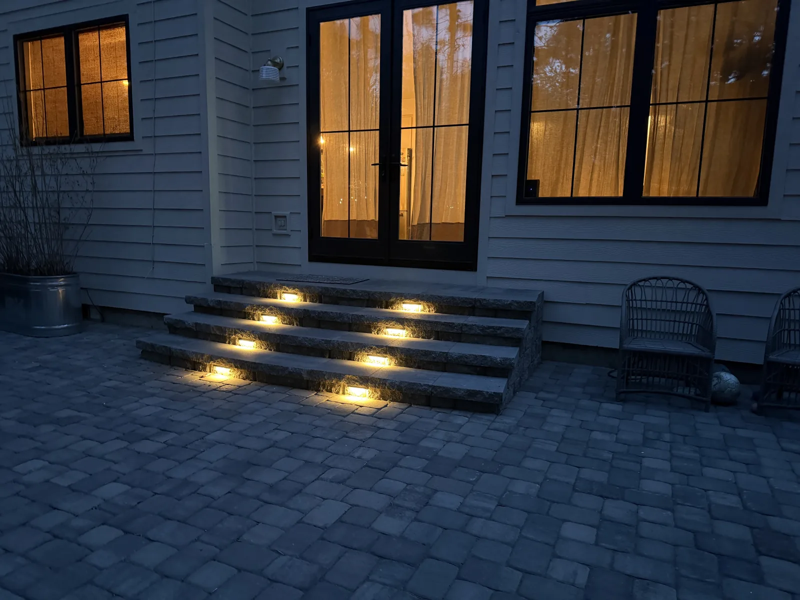 Granite stone steps with recessed step lights leading up to a back patio door