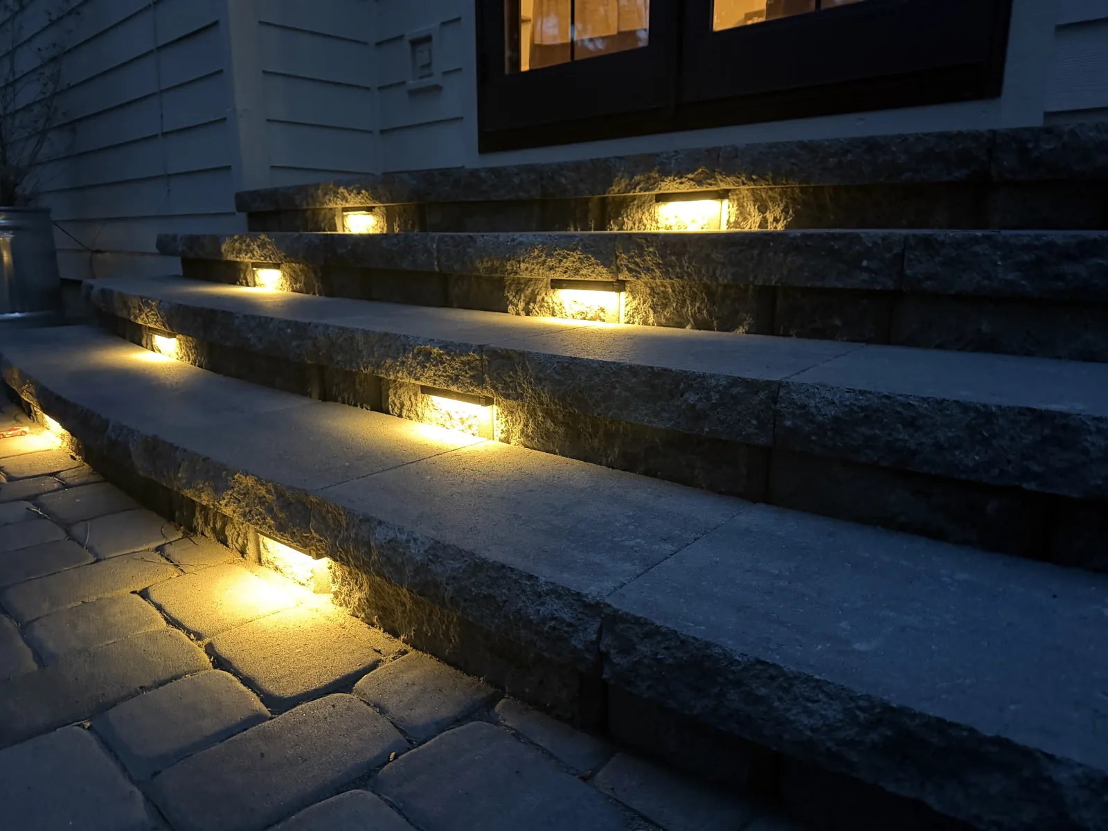 Close-up of integrated recessed step lights on natural granite stone risers