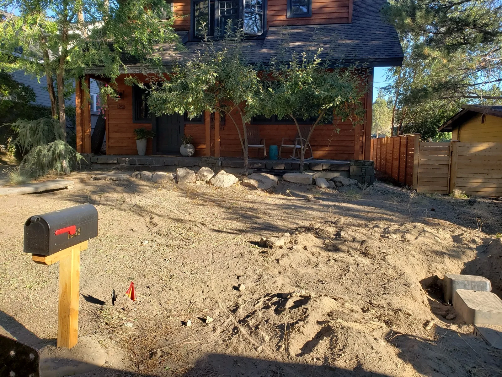 Bare dirt front yard before hardscape installation